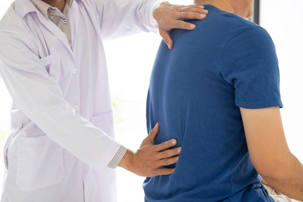 doctor-physiotherapist-treating-lower-back-pain-pa-KUDD5HQ-scaled-e1658263871351.jpg