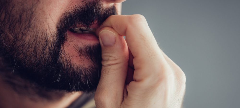 Close up of nervous male biting fingernails